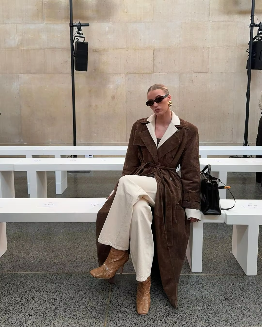 Frau in braunem Mantel und Sonnenbrille auf Bank, Mode, Herbstoutfit, eleganter Stil.