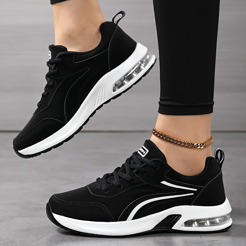 Svarta snörsneakers med vita ränder och synlig luftkudde i den vita sulan, där ena foten lyfts och skon syns från sidan. 3