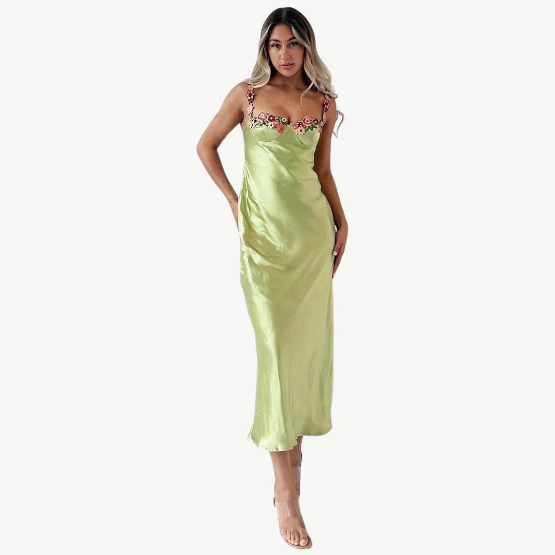 Frau in grünem Satin-Slip-Kleid mit Blumenmuster, elegantes Abendkleid, Modefotografie.