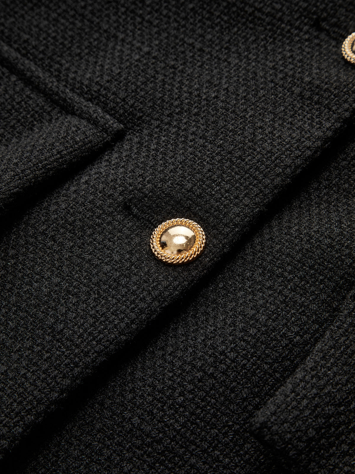 Schwarzer Wollmantel mit goldenen Knöpfen, elegantes Design, hochwertige Damenmode.