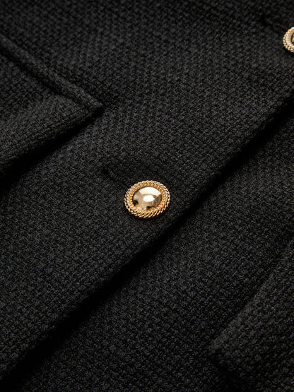 Schwarzer Wollmantel mit goldenen Knöpfen, elegantes Design, hochwertige Damenmode.