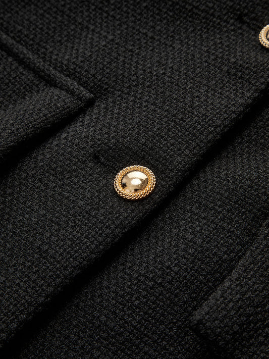 Schwarzer Wollmantel mit goldenen Knöpfen, elegantes Design, hochwertige Damenmode.
