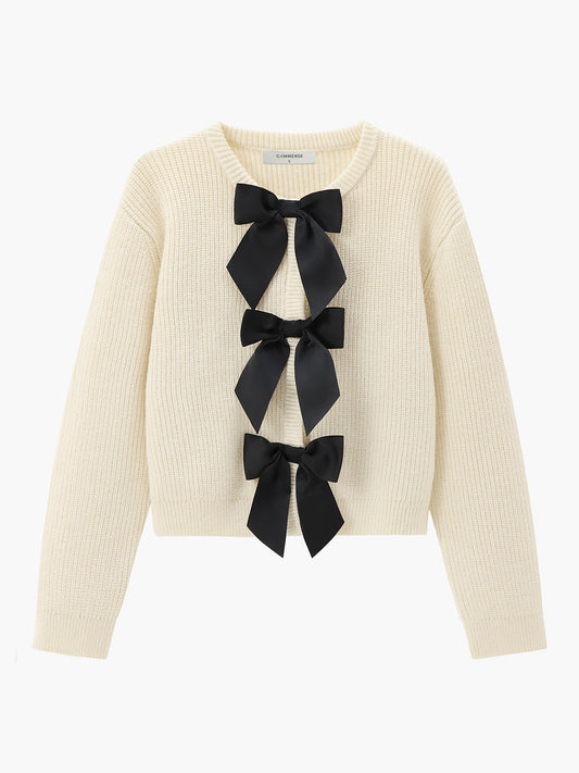 Cremefarbener Strickpullover mit schwarzen Schleifen, Damenmode, eleganter Herbst-Look.