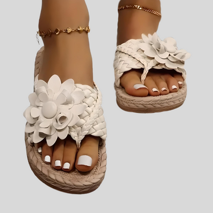 Weiße Damen-Sandalen mit Blumenmuster, geflochtenem Design und Keilabsatz.