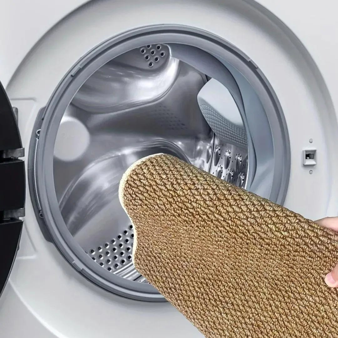 Brun matta hålls framför den öppna luckan på en tvättmaskin, för maskintvätt 7