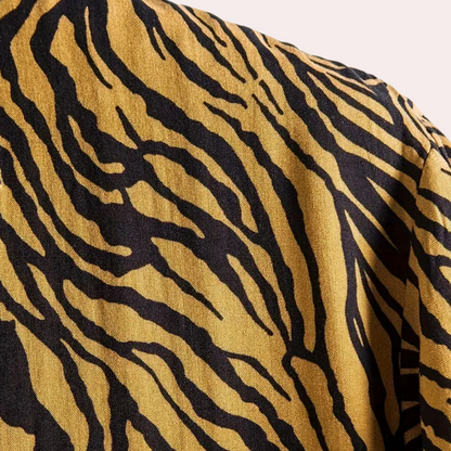 Tigerstreifen-Muster auf gelbem Stoff, modisch, Textildesign, trendig, auffällig.