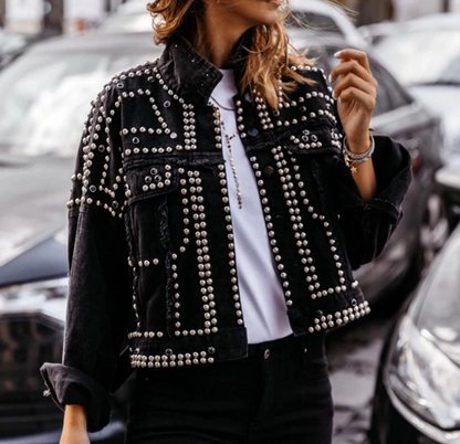 Frau trägt schwarze Jeansjacke mit Nieten, modisch, urbaner Stil, Straßenmode.