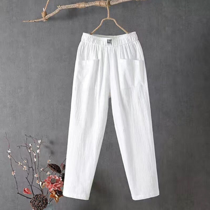 Weiße Leinenhose, elastischer Bund, Damenmode, minimalistisch, hängend an Ast.