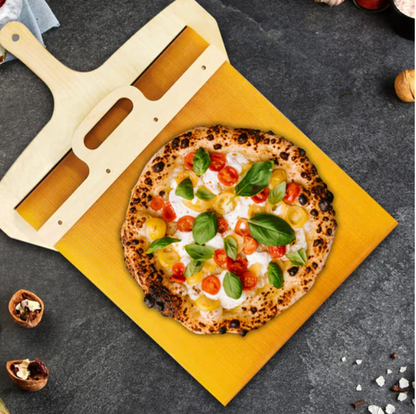 Holz-Pizzaschieber mit frischer Pizza, Tomaten, Basilikum auf grauem Hintergrund.