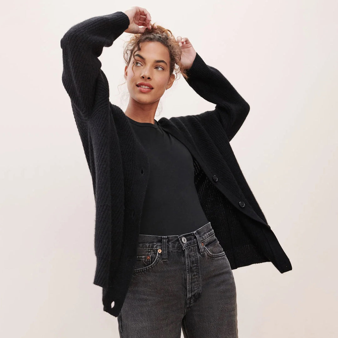 Frau in schwarzem Strickcardigan und Jeans, lässige Mode, Herbstoutfit, Damenbekleidung.
