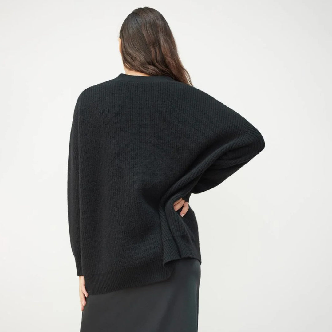 Frau in schwarzem Strickpullover, Rückansicht, lässige Mode, Herbst-Winter-Kollektion.