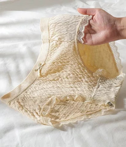 Damenunterwäsche aus Spitze, beige, atmungsaktiv, komfortabel, handgehalten auf weißem Hintergrund.