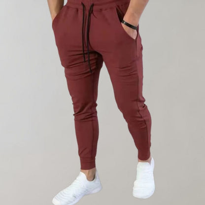 Rote Jogginghose für Herren, bequem, sportlich, mit Kordelzug, ideal für Freizeit und Fitness.