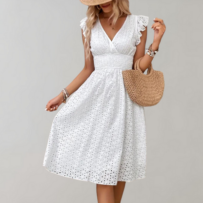 Frau in weißem Sommerkleid mit Strohhut und Tasche, Spitzenmuster, modisch, elegant.