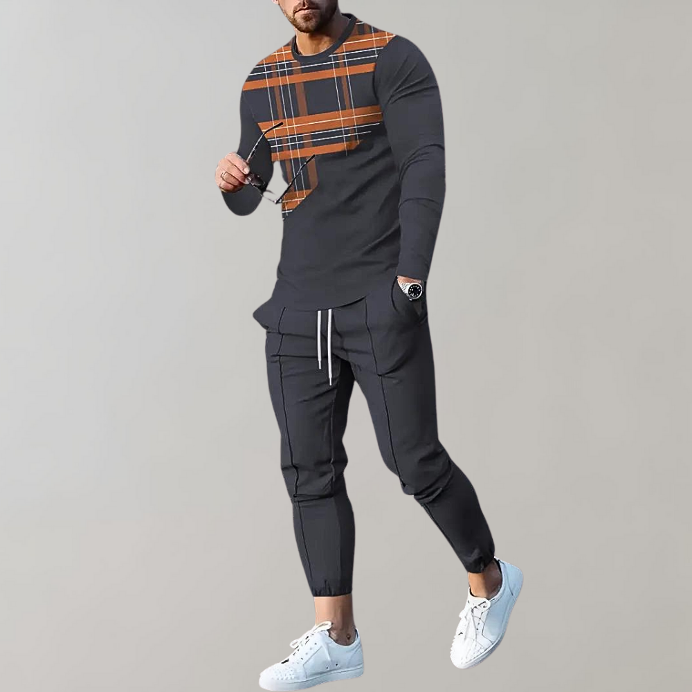 Mann in grauem Trainingsanzug mit Karomuster, weiße Sneaker, sportlich, modern.