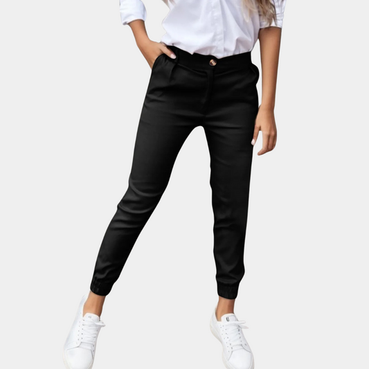 Frau in schwarzer Hose und weißem Hemd, weiße Sneaker, modische Damenbekleidung.
