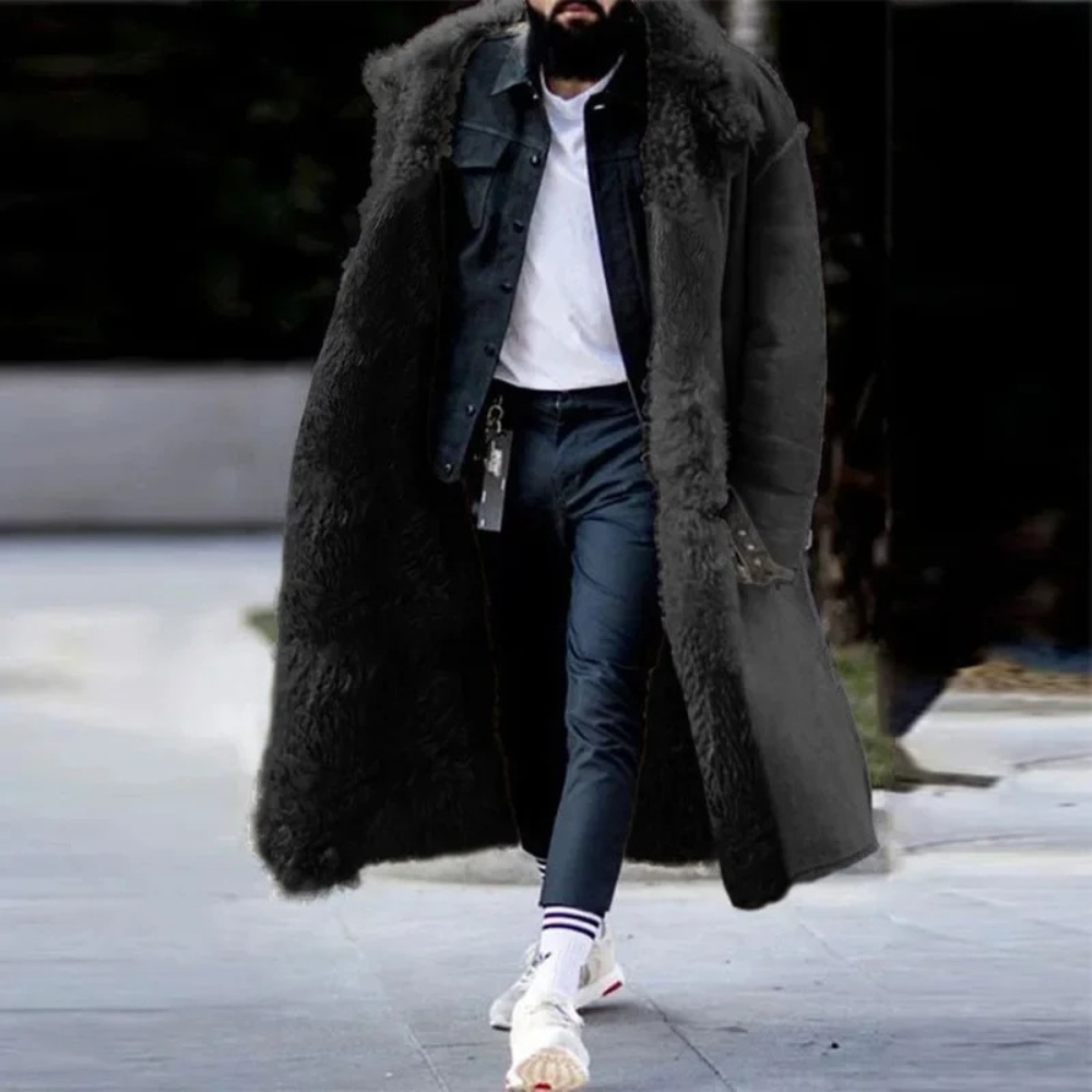Mann in schwarzem Lammfellmantel, Jeansjacke, weißem T-Shirt, lässiger Wintermode.