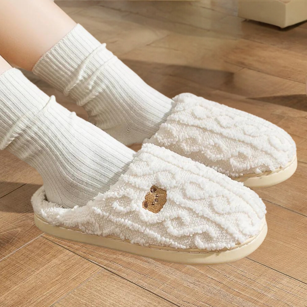 Weiße Plüsch-Hausschuhe auf Holzboden, gemütlich, rutschfest, Damenmode, Winterbekleidung.