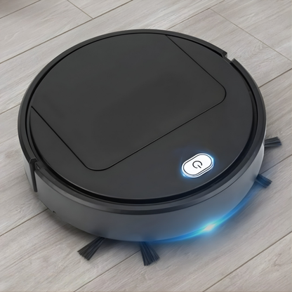 Svart robotdammsugare på ett ljust trägolv med lysande strömknapp och blått ljus längs kanten, sidoborstar synliga framtill. 2