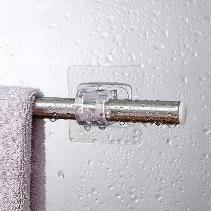 Klämhållare på en våt vägg med vattendroppar, som bär en blank metallstång med en ljuslila handduk. 4