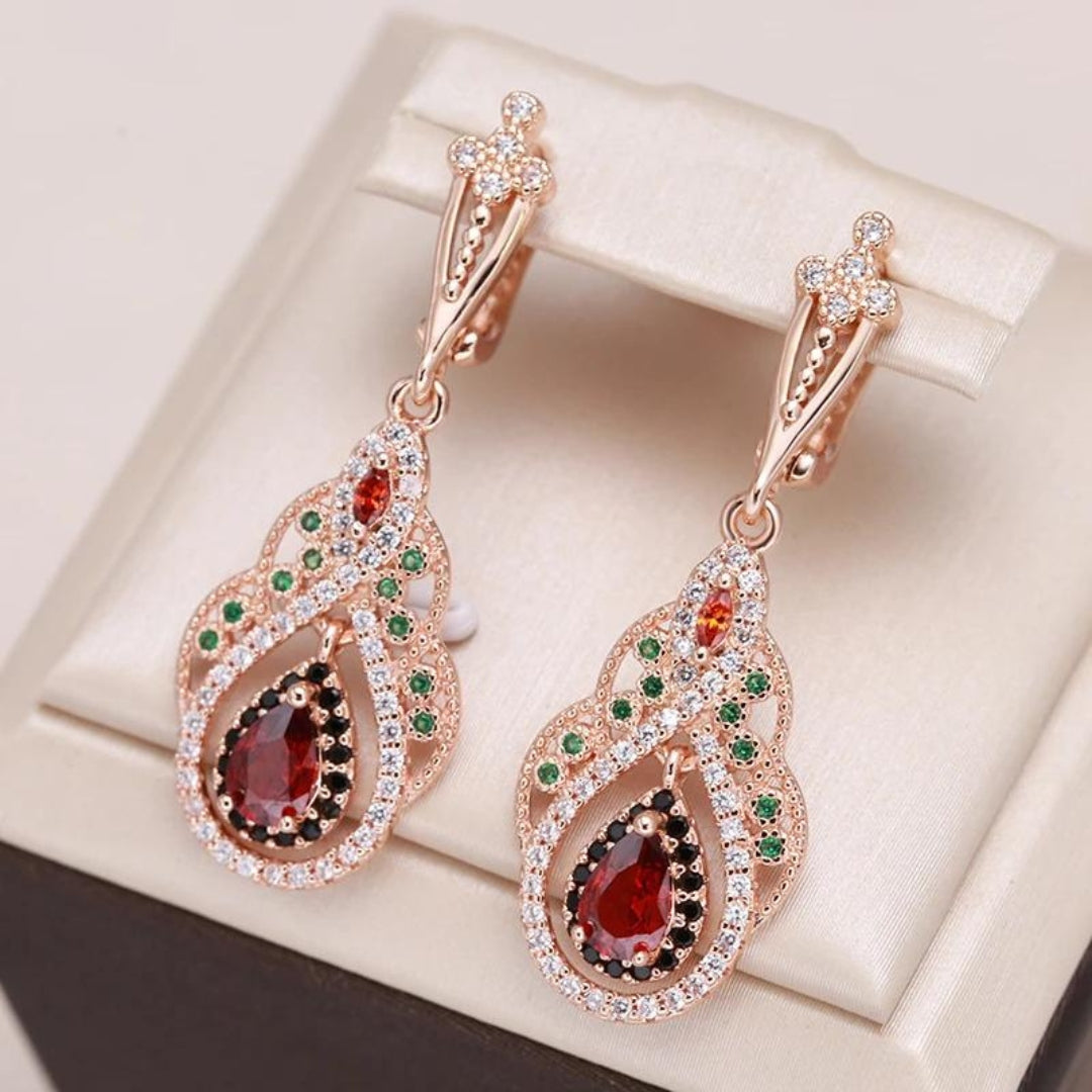 Roségold Ohrringe mit roten und grünen Edelsteinen, tropfenförmig, luxuriöses Schmuckdesign.