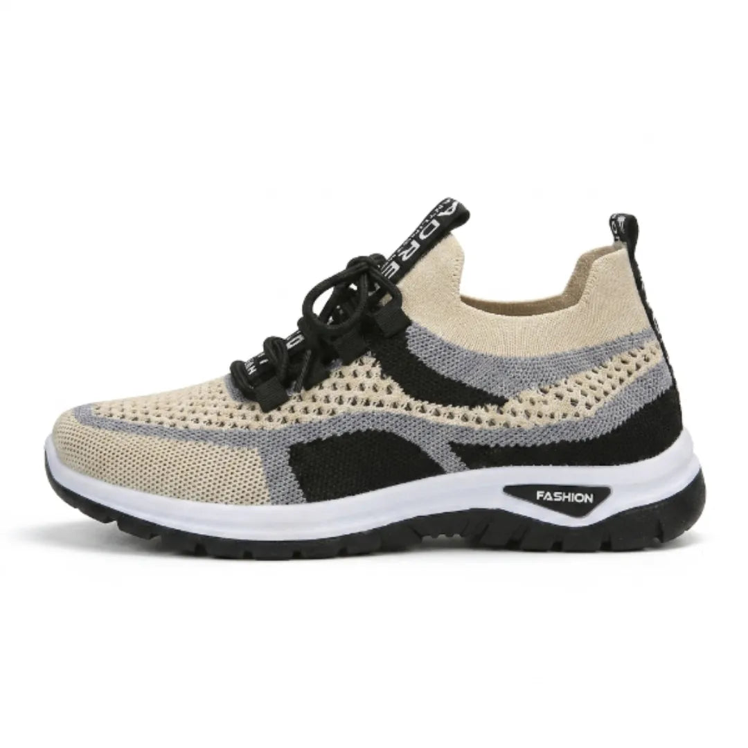 Sidovy av en beige sneaker i mesh med svarta och grå fält, svarta snören och svart sula. 37