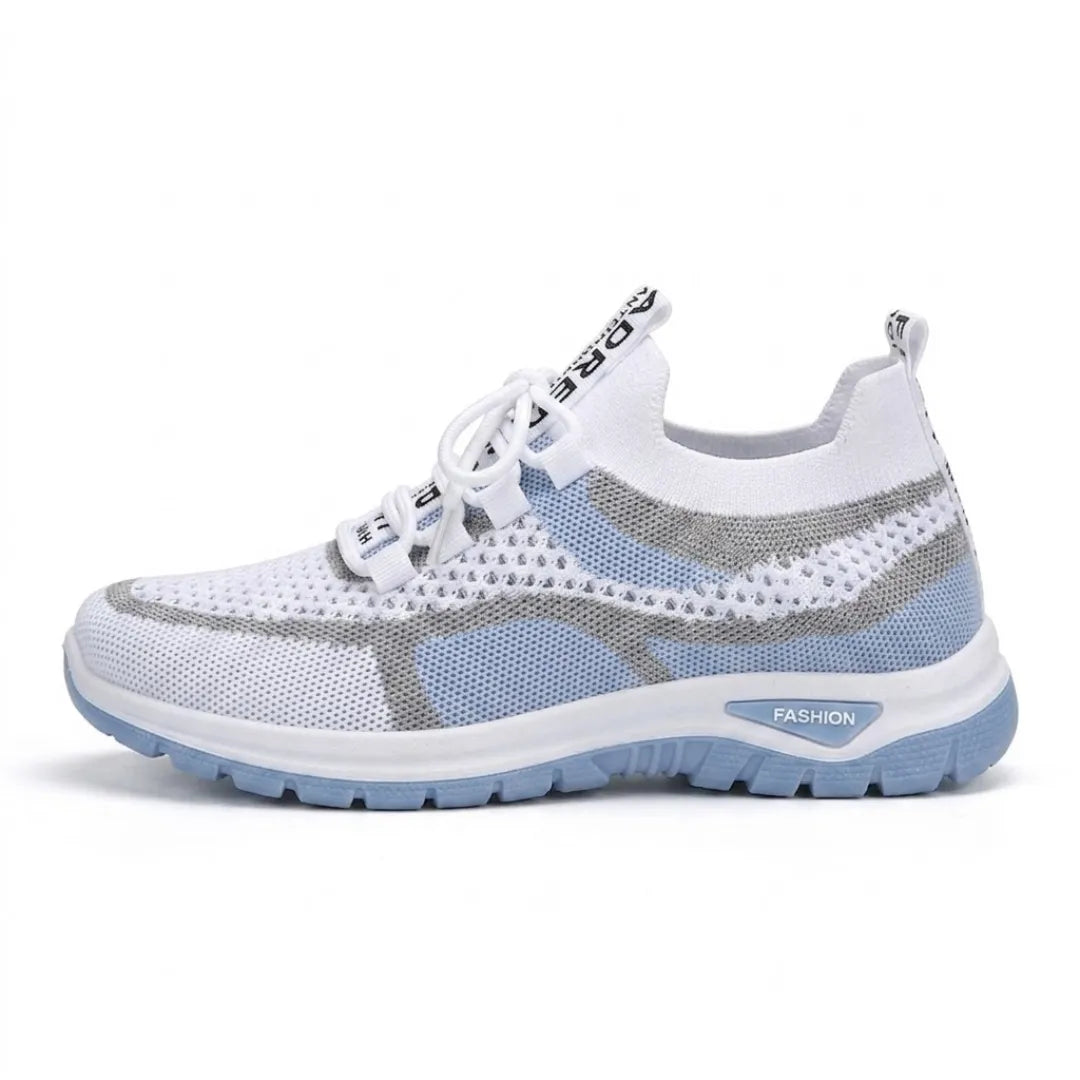 Sidovy av vit sneaker i mesh med ljusblå och grå partier, ljusblå sula och snörning, mot vit bakgrund. 1
