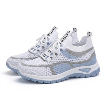Ett par vita och ljusblå mesh-sneakers med vit snörning och blå sula, snett framifrån mot vit bakgrund. 7