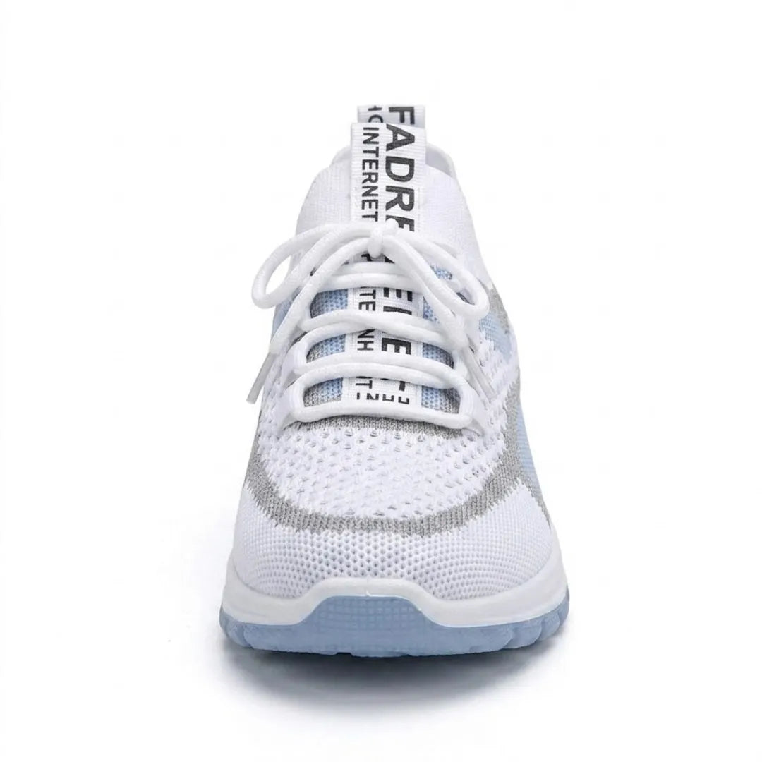 Framifrån sedd vit sneaker med ljusblå detaljer, snörning och textilband på tungan, ljusblå sula. 8