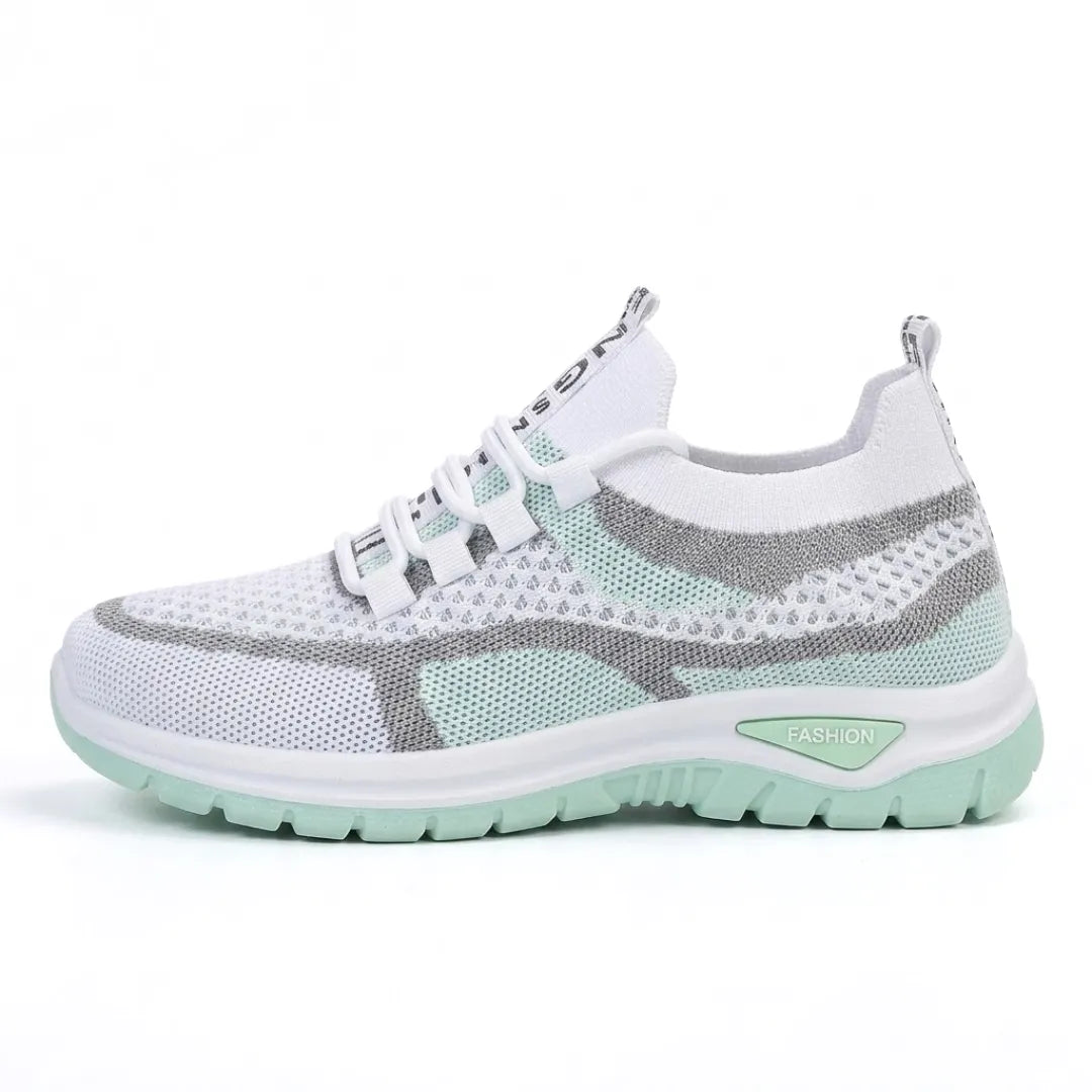 Sidovy av vit sneaker i mesh med mintgröna och grå partier och mintgrön sula, mot vit bakgrund. 10
