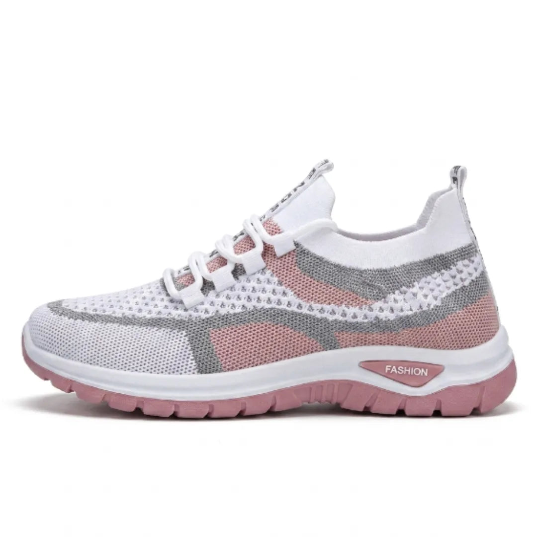 Sidovy av vit sneaker i mesh med rosa och grå partier, rosa sula och snörning, mot vit bakgrund. 19
