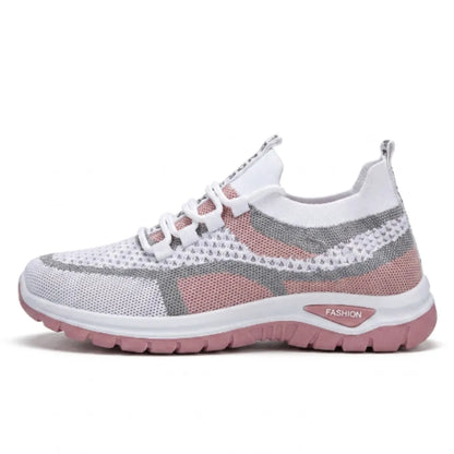 Sidovy av vit sneaker i mesh med rosa och grå partier, rosa sula och snörning, mot vit bakgrund. 19