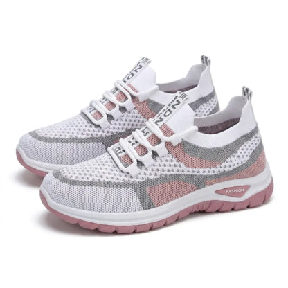Ett par vit-rosa sneakers i luftigt mesh med grå detaljer och rosa sula, snett framifrån. 25