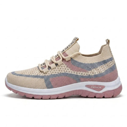 Sidovy av en beige sneaker i mesh med rosa och blågrå fält, vit mellansula och rosa yttersula. 28