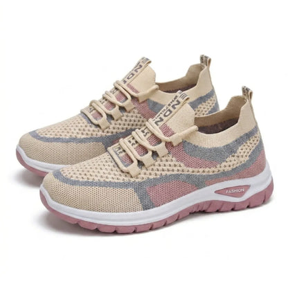 Ett par beige sneakers i mesh med rosa och grå fält och rosa sula, snett framifrån. 34