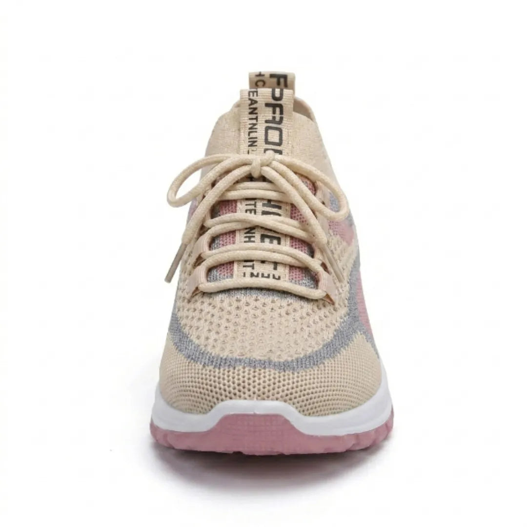 Beige sneaker framifrån med snörning, bred tåkåpa i mesh och rosa sula. 35