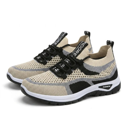 Ett par beige sneakers med genombrutet mesh, grå och svarta detaljer, snören och vit sula, sedda snett framifrån. 43