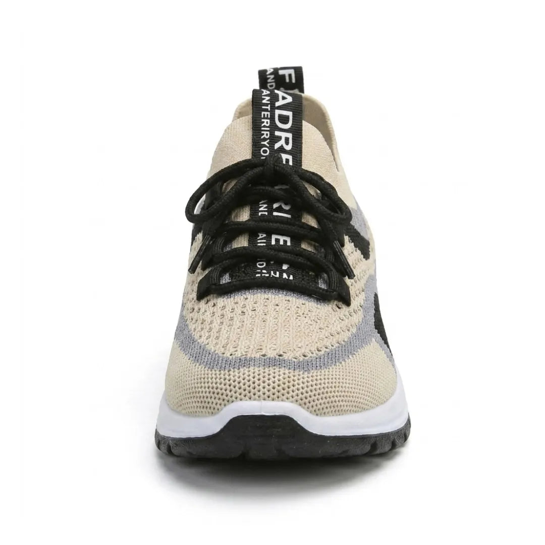 Sneakern rakt framifrån med beige mesh, svarta snören, grå och svarta fält samt dragflik med tryck på hälen. 44
