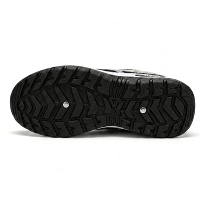 Undersidan av sneakern med svart sula med kraftigt mönster med zigzagrillor för grepp och två små metallnitar. 45