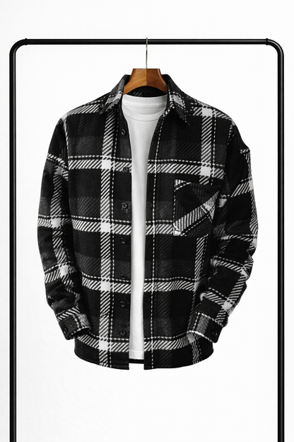Overshirt med stor svartvit rutmönstring på galge, uppknäppt över vit t-shirt, med bröstficka och mörka knappar. 3
