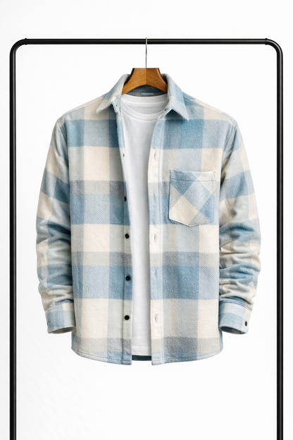 Rutig overshirt i ljusblått och benvitt på galge, uppknäppt över en vit t-shirt, sedd framifrån med bröstficka. 1