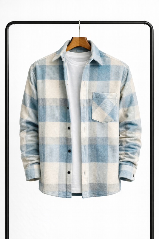 Rutig overshirt i ljusblått och benvitt på galge, uppknäppt över en vit t-shirt, sedd framifrån med bröstficka. 1