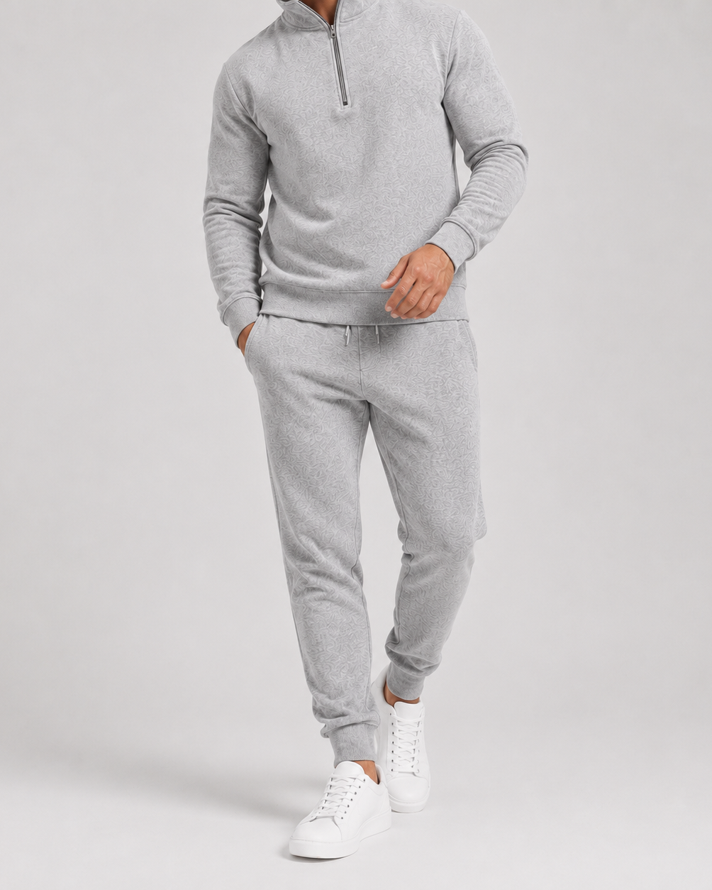 Ljusgrått set i halvfigur nerifrån midjan, med dragkedja i kragen, resår i byxbenen och vita sneakers 2