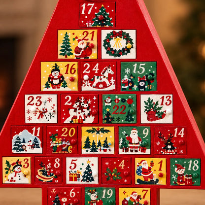 Närbild på adventskalenderns små lådor med handmålade jultomtar, snögubbar och julgranar och runda knoppar som handtag. 3