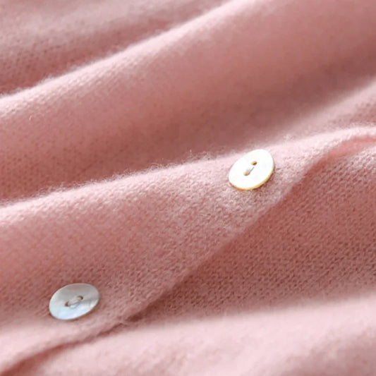 Rosa Kaschmirpullover mit Perlmuttknöpfen, weiches Material, luxuriöse Damenmode.