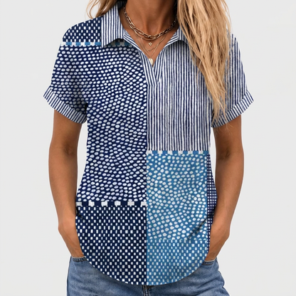 Närbild framifrån på kortärmad skjorta med V-ringning och uppvikta ärmar, bärs med jeans och halsband 1