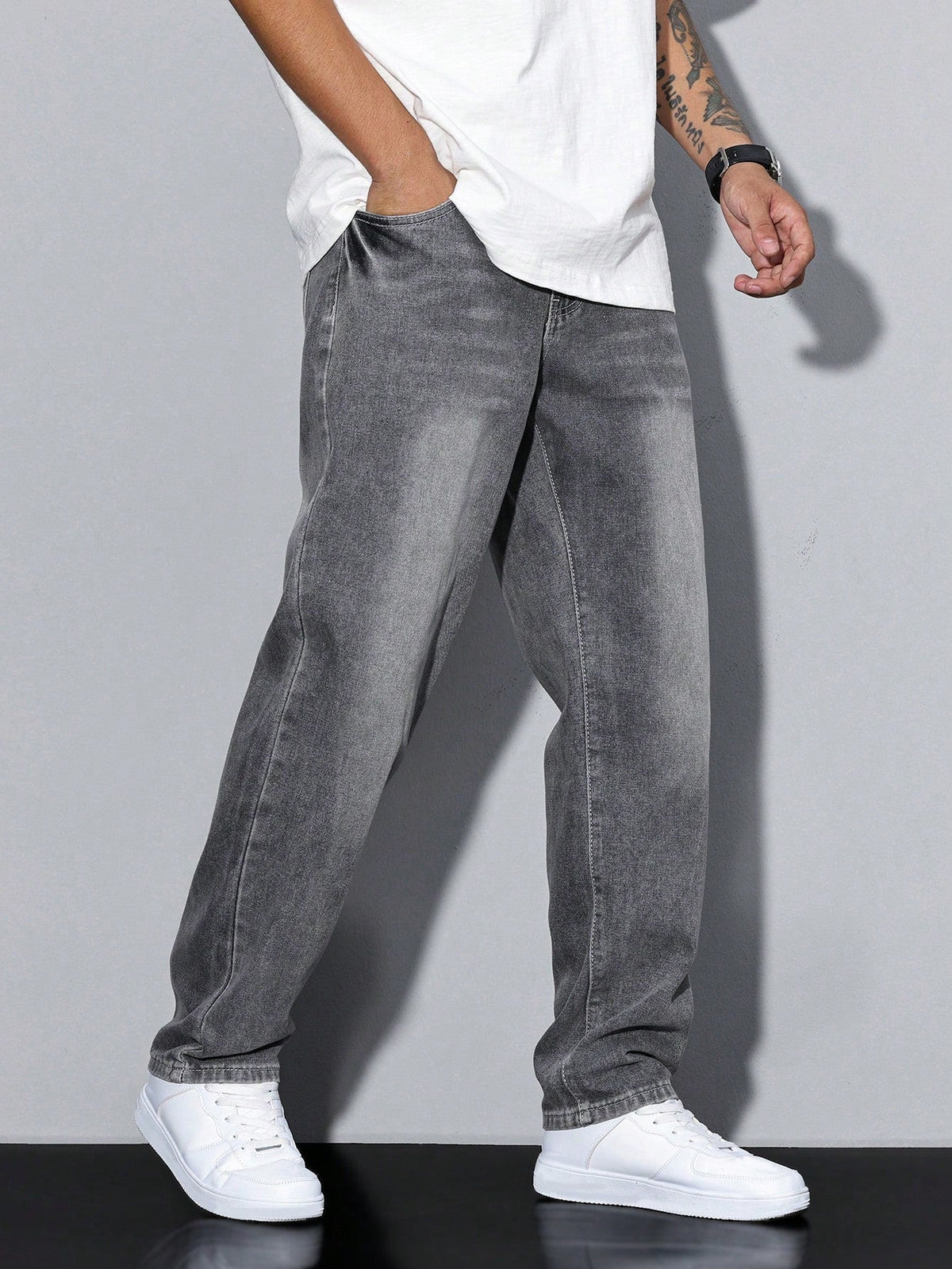 Gråtvättade jeans med rak passform sedda snett från sidan, burna av modell med handen i framfickan. 2