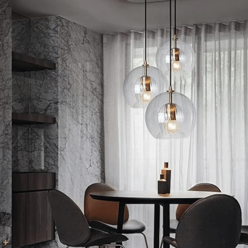 Moderne Esszimmerbeleuchtung, Glaspendelleuchten, runder Tisch, elegante Inneneinrichtung.