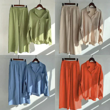Vier Sets aus Leinen, bestehend aus Hemd und Hose in Grün, Beige, Blau und Orange, auf Kleiderbügeln.