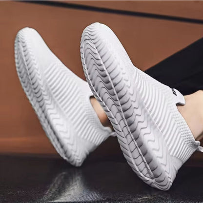 Weiße Sneaker mit wellenförmiger Sohle, atmungsaktives Material, modisches Design.